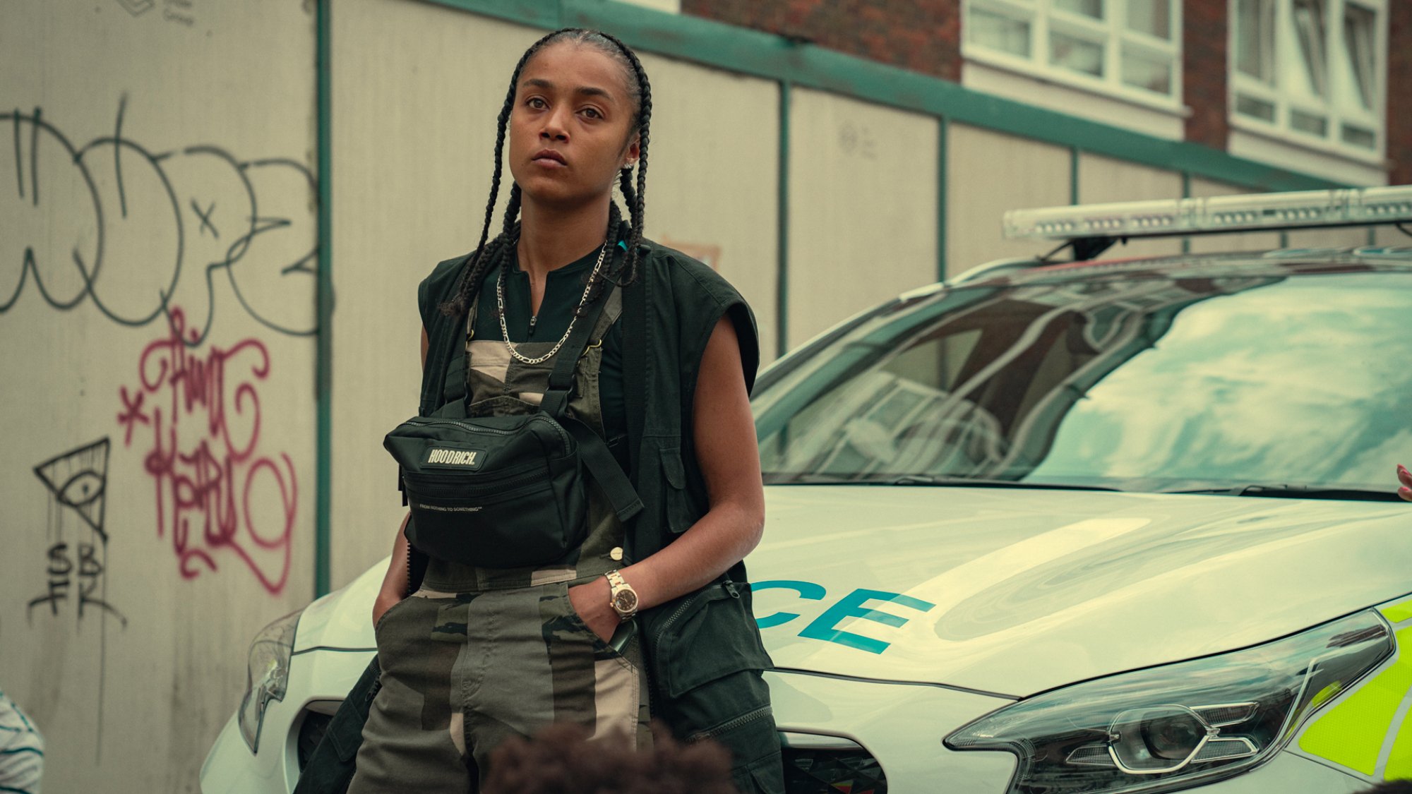 Jasmine Jobson sits on the front of a police car in the TV show "Top Boy"
