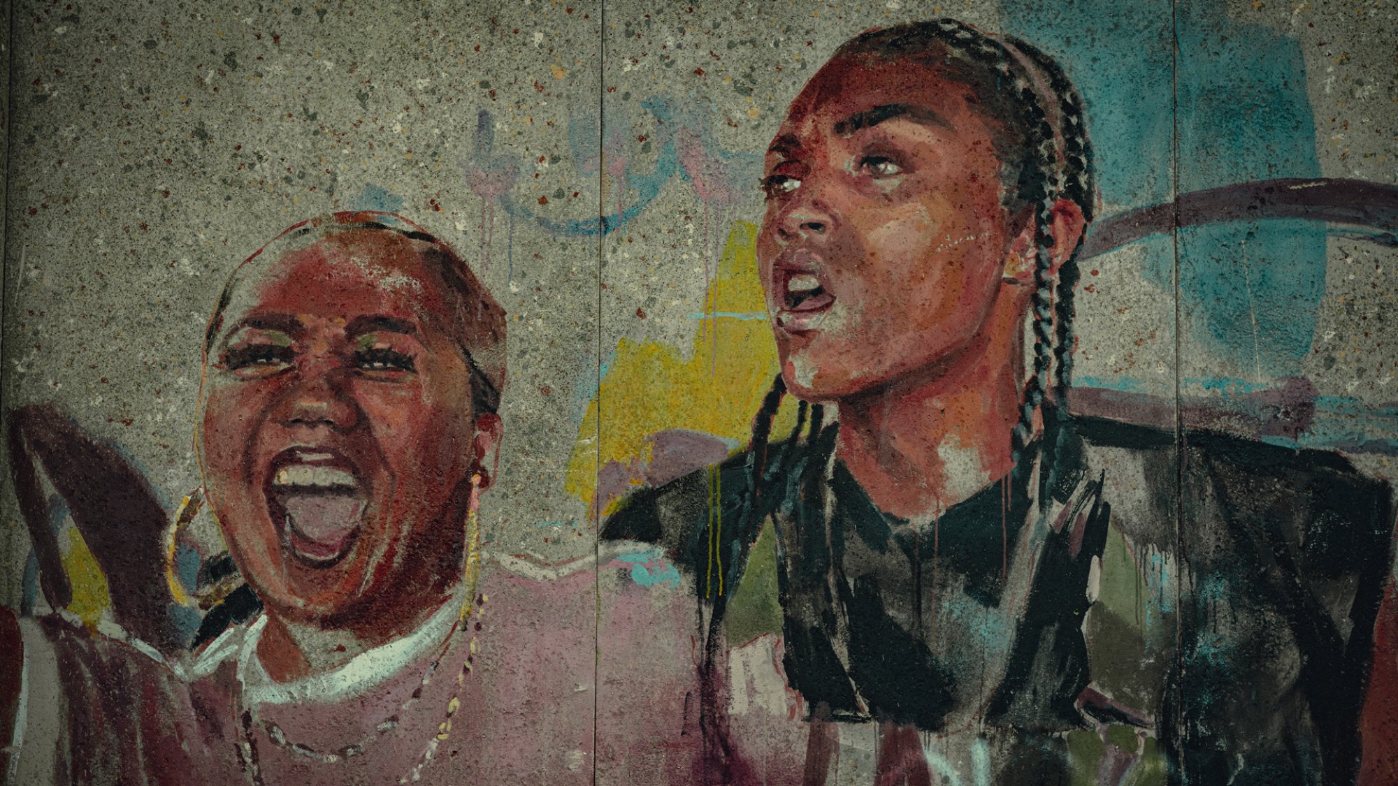 A mural of two women smiling and protesting in the show "Top Boy"